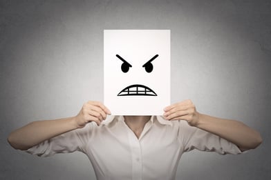 businesswoman covering her face with angry mask isolated grey wall background. Negative emotions, feelings, expressions, body language.jpeg